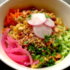 Crushed peanuts, radishes, carrots, scallions, pickled red onions and more top chilled noodles bathed in a creamy peanut sauce
